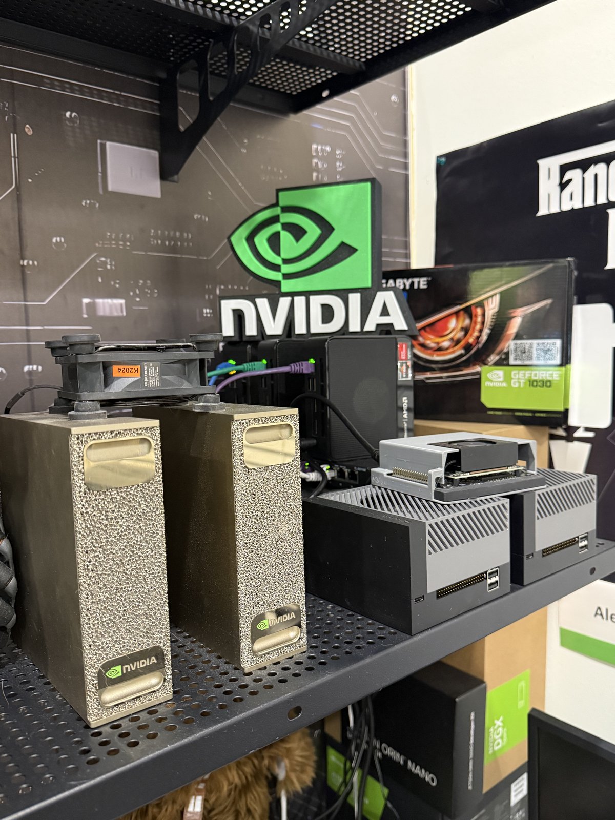 Two gold DGX Spark units on a shelf next to Jetson AGX Orin developer kits